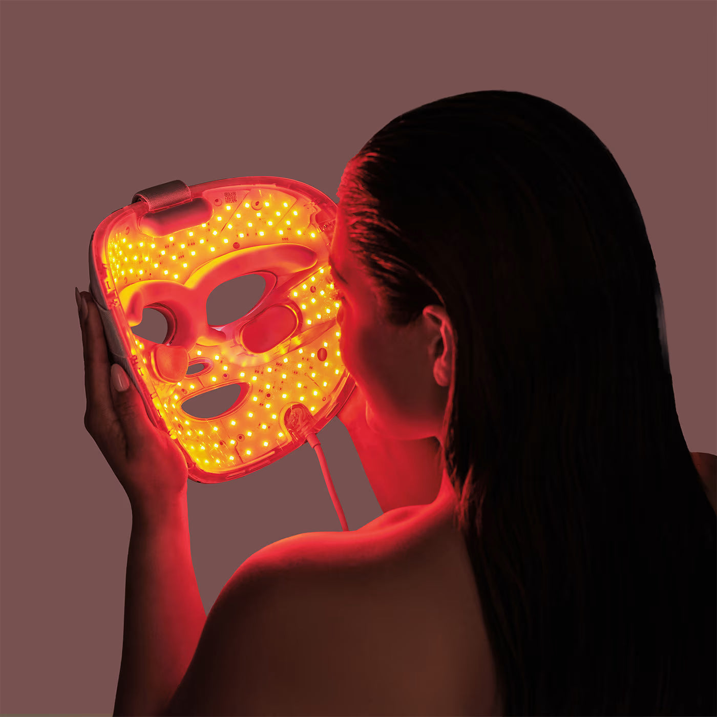 woman using red light therapy mask safely for facial skincare